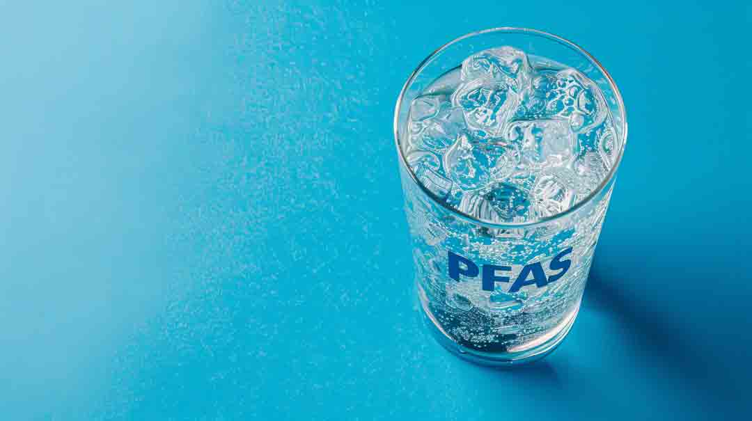 Glass of water labeled PFAS