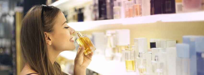 Woman smelling a perfume bottle.
