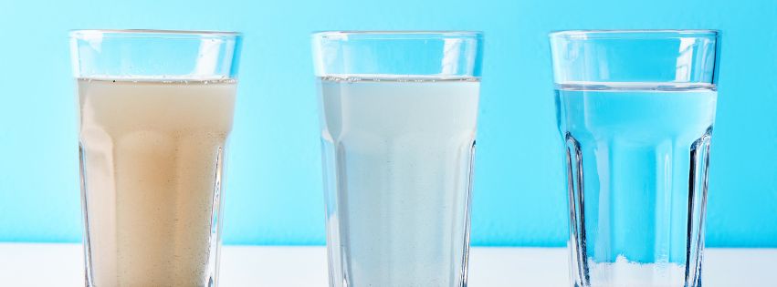 # glass cups filled with dirty water, semi dirty water, and clean water.