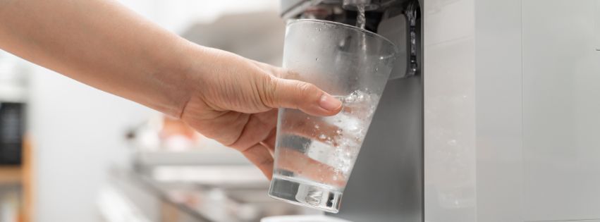 A person filling a glass with water.