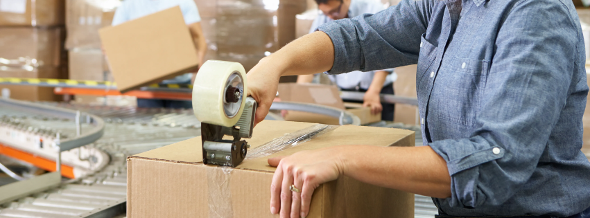 A person taping a box closed.