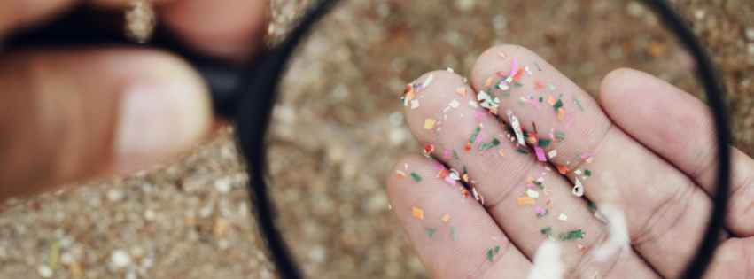 A magnifying glass observing small plastics