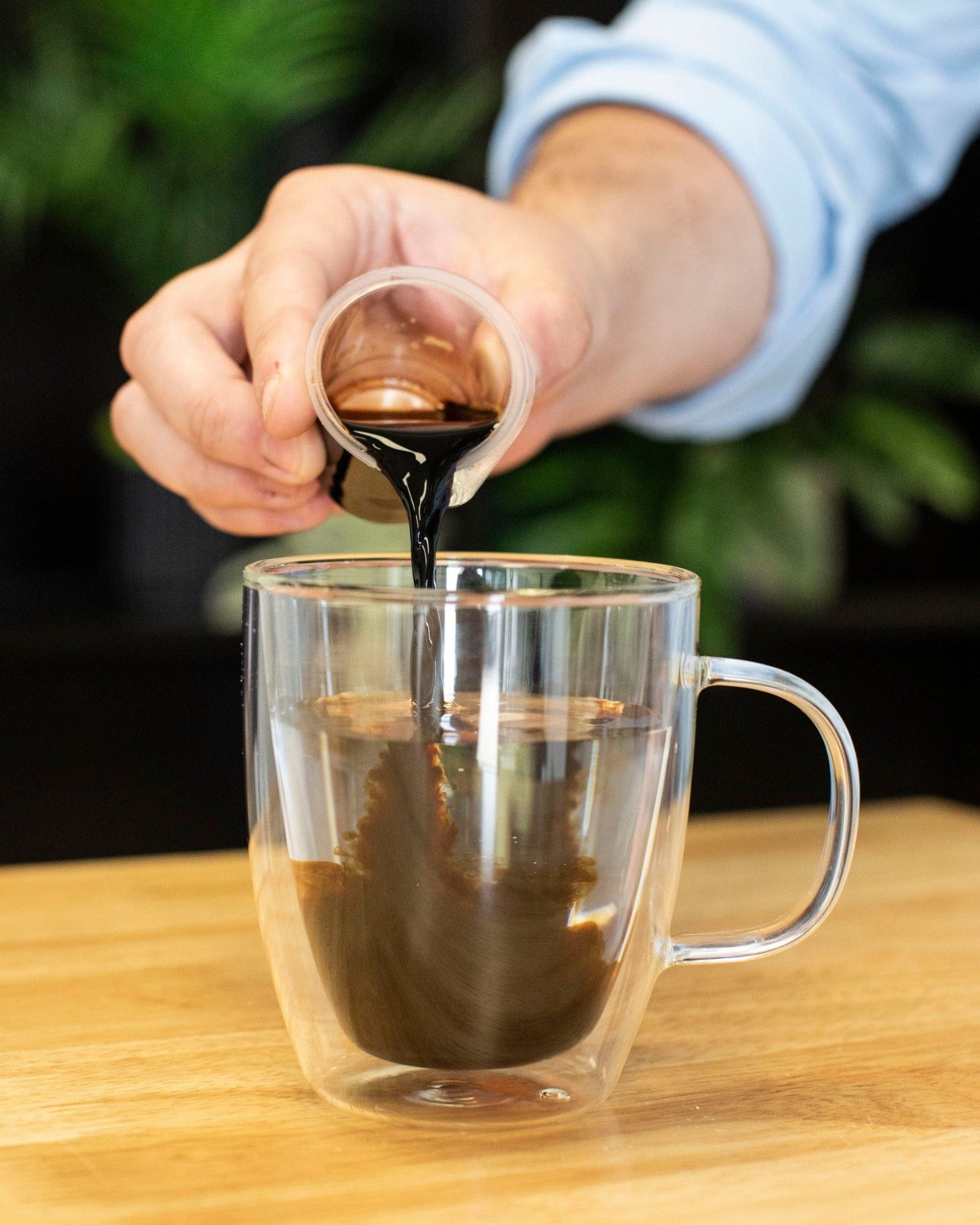 Pouring hot water into a glass mug from a Bottleless Nation dispenser