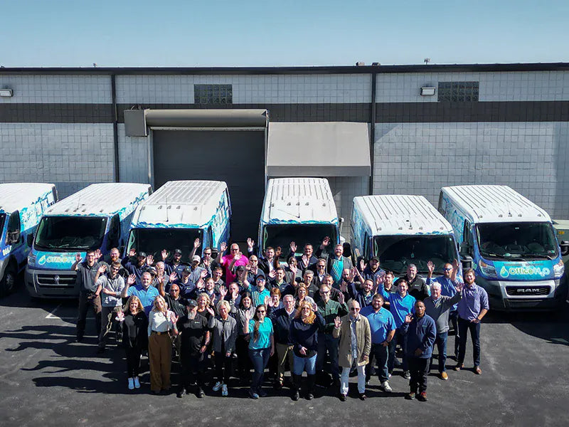 Bottleless Nation team with branded service vans outside headquarters