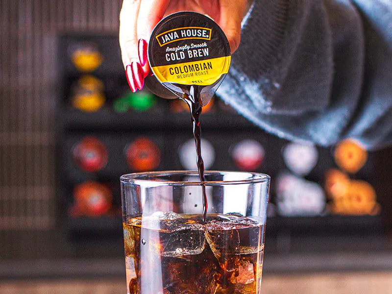 Beverage being poured into a glass of ice