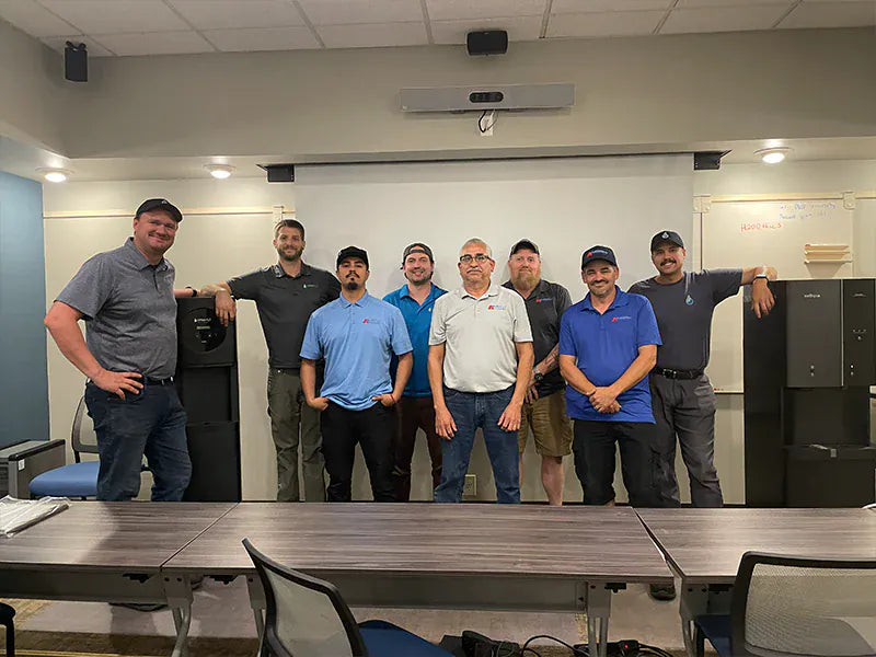 Bottleless Nation team standing with water and ice dispensers in a training room